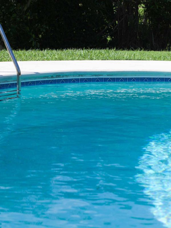 Eau claire et scintillante d’une piscine avec mosaïque bleue, mettant en avant un service professionnel d’entretien et de nettoyage de piscines à Genève par Alfredo Services.