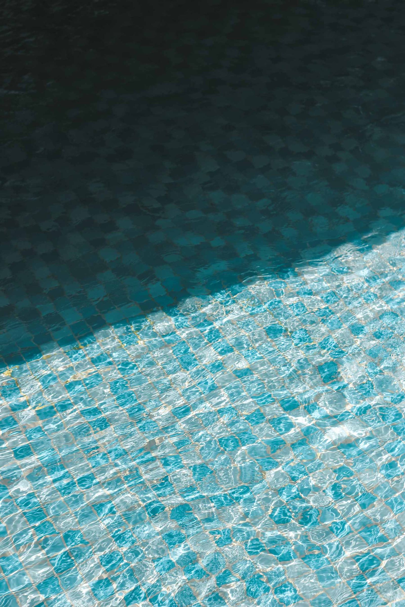 Eau claire et scintillante d'une piscine avec mosaïque bleue, mettant en avant l'entretien des piscines et bassins à Genève.