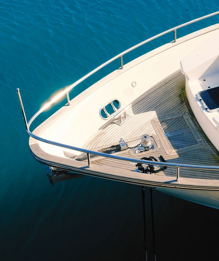 Pont d’un yacht propre et bien entretenu sur une eau turquoise, mettant en avant un service de nettoyage et detailing de bateaux à Genève.